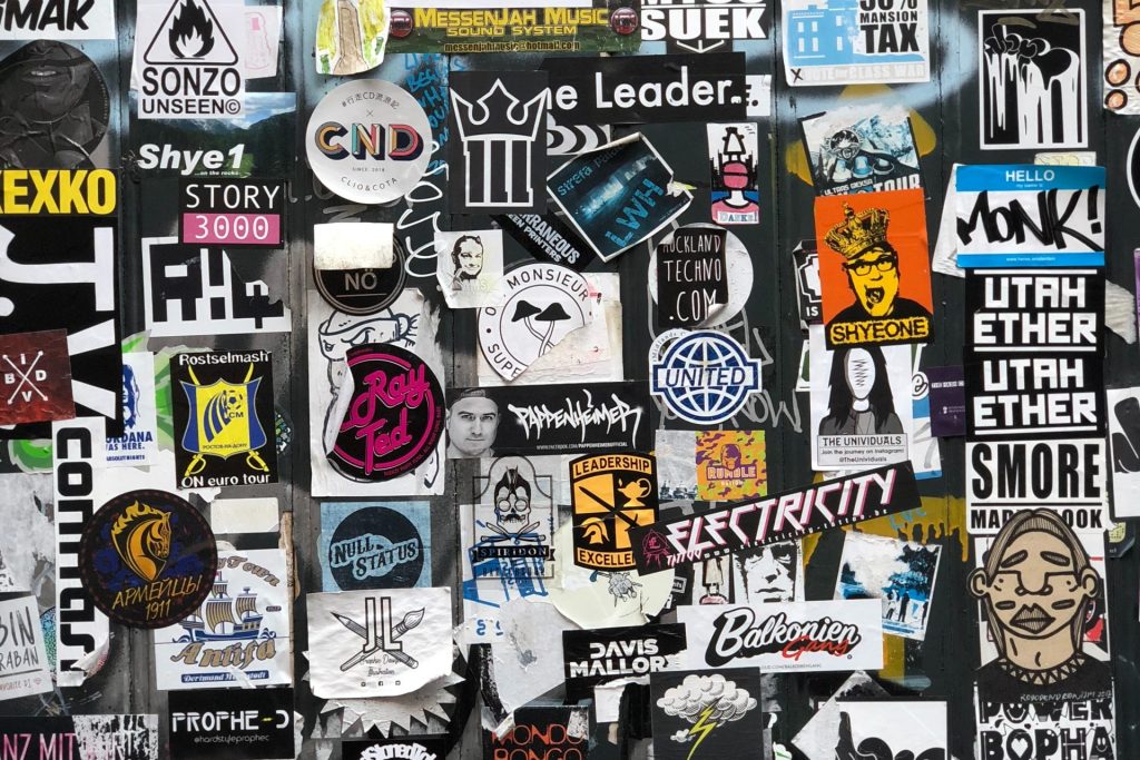 Wand mit unglaublich vielen Stickern übereinander und nebeneinander